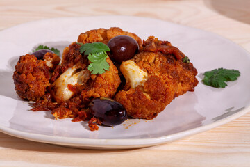 Cauliflower with tomato sauce cooked salad with olives. Moroccan cuisine.