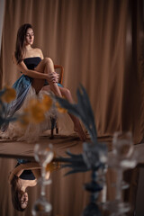 Indoor art portrait of young beautiful woman in her bedroom among flowers