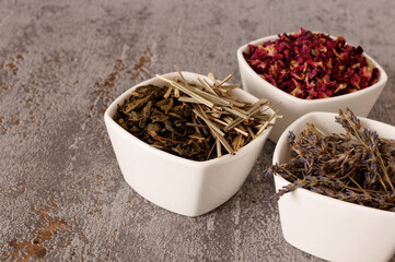 Dried plants parts in bowls. Lavender, lemongrass, green tea and rose petals. Self made potpourri.