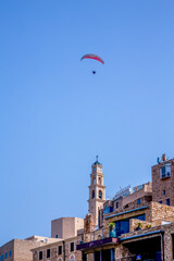 Fototapeta na wymiar Tel Aviv-Jaffo, Israel - March 15, 2021: Panoramic view of Jaffa's ancient port and paraglider flying with paramotor on air