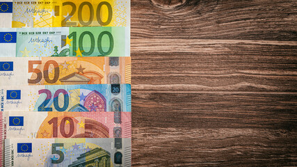 Eurobanknoten liegen auf einem Holztischtisch - Finanzen Geld Hintergrund Panorama