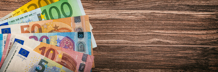 Eurobanknoten liegen auf einem Holztischtisch - Finanzen Geld Hintergrund Panorama
