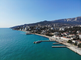 Fototapeta na wymiar Embankment of the city of Yalta, Crimea on sunny spring day sea view. Photo made by drone from above