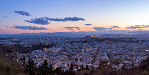 View of the city of Athens, during sunset. On the right there can be seen Acropolis and the Parthenon, and on bottom left the Greek Parliament.