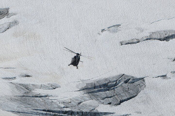 Swiss Airforce EC 635 Helicopter flying over a glacier
