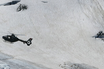 Swiss Airforce EC 635 Helicopter flying over a glacier