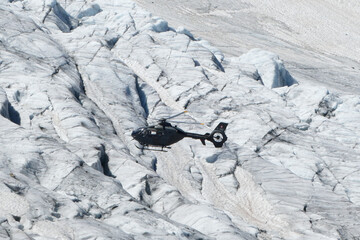 Swiss Airforce EC 635 Helicopter flying over a glacier