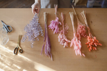 Armfuls of dried flowers standing in a vase. Beautiful dried flowers of delicate shades. Materials for a workshop on making bouquets