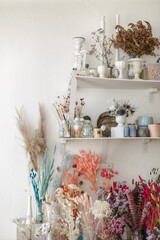 Shelves with vases and dried flowers in the florist's workshop