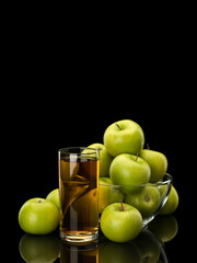 Apple juice and fruits of green apples in glassware