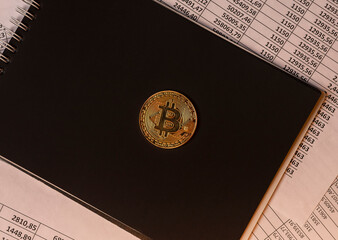 Shining golden bitcoin coin on documents, btc