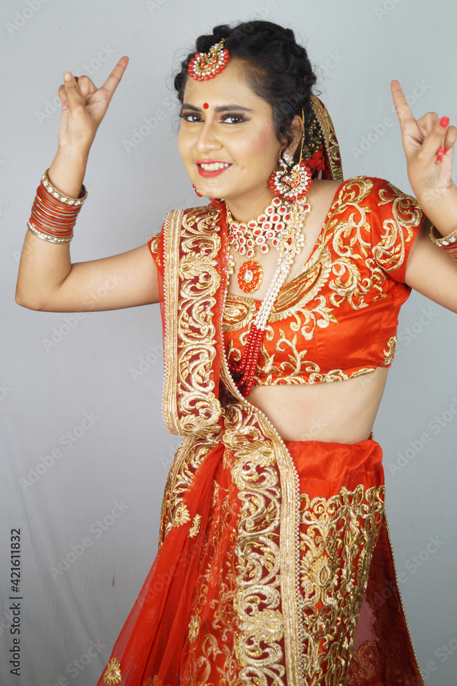 Wall mural pretty indian bride with heavy makeup and traditional indian bridal attire showing peace gesture