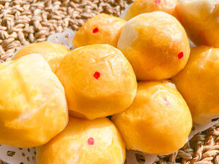 Close up moon cake traditional Chinese cake pastry with salted egg lava on white dish plate on Woven rattan background. Famous sweet dessert in Asia ancient party or local festival. Close up.