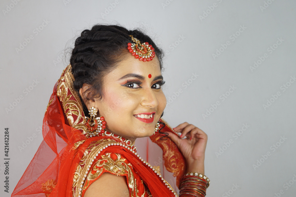 Wall mural gorgeous indian bride with heavy makeup wearing traditional indian bridal attire and posing