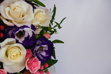 Background. Bouquet of flowers close-up on a white background. White and pink roses, blue-white eustoma. Place for text.