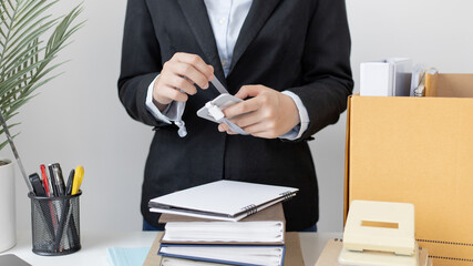 Put the work equipment in the office in a large brown box, Businessmen are keeping work documents and personal belongings due to resignation or being fired, termination of employment.