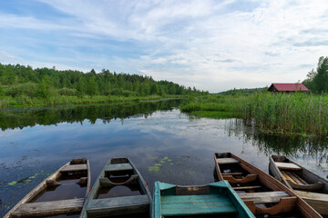 Fototapeta na wymiar Old wooden boats near the river pier on a warm summer day.