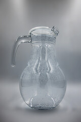 transparent glass jug on gray background