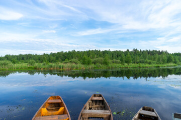 Naklejka premium Old wooden boats near the river pier on a warm summer day.