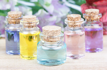 Set of colorful bottles with floral essential oil.