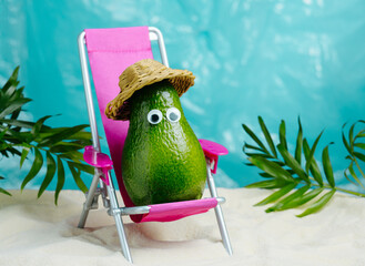 Avocado in hat  relaxes on  lounge chair on  beach. Summer tropical minimal humor poster.