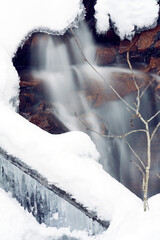 Ice under snowy river. Waterfall under the cracks in a icy river. 