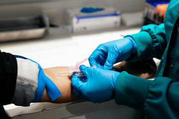 Latino woman has blood drawn at medical facility by healthcare professional