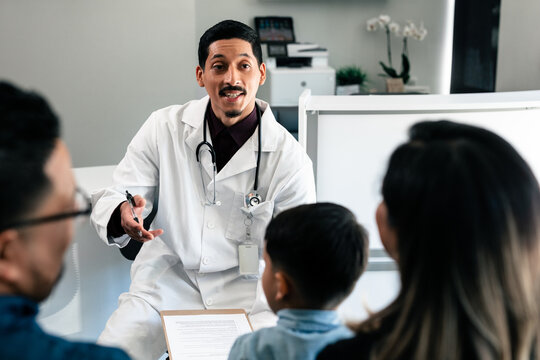 Hispanic Doctor Reviewing Translated Documents With Diverse Patients