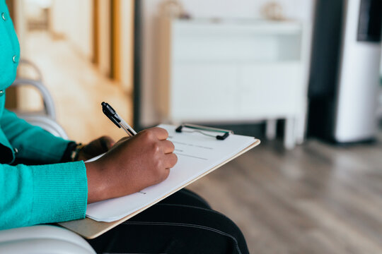 Black Woman Completing Medical Paperwork And Healthcare Forms On Clipboard