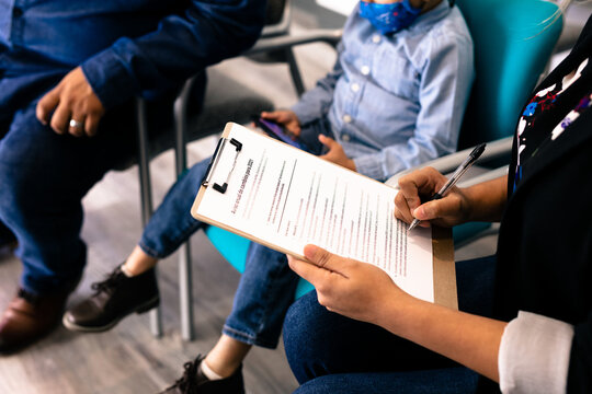 Hispanic family completing Spanish translated medical forms in doctor office