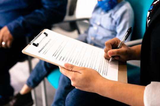 Hispanic family completing Spanish translated medical forms in doctor office