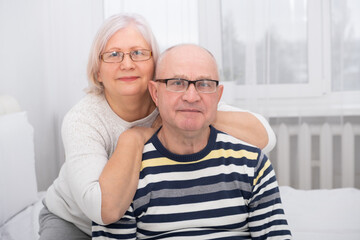 portrait of senior woman hugging senior man at home. couple in love
