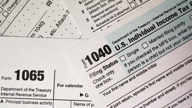 A lot of tax forms include 1040 Individual Income Tax Return, zoom out and zoom in footage, concept of business deals