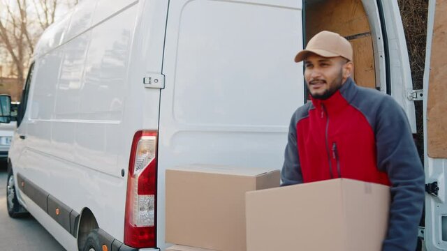 delivery men unloading cardboard boxes from truck on street. High quality 4k footage