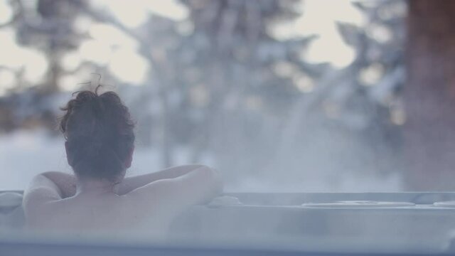 Nordic spa in a winter paradise. Escape the city and the bustle of every day. Hot spring overlooking the fresh snowfall in a winter retreat. Shot in 4k. 