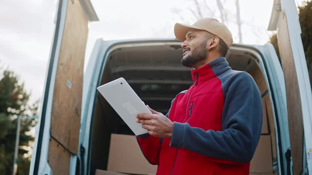 Courier with digital tablet delivering package. Mailman in front the van. High quality 4k footage