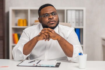 Freelance designer workplace at home office. Young African-American man works using a computer, graphics tablet and other devices. Remote job.
