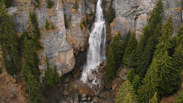 Drone flying over a green forest around a big waterfall in the mountains. Aerial Drone footage 4K. Beautiful nature landscape scene showing the famous waterfall in the Carpathian Mountains, Vanturis