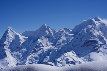 Fototapeta na wymiar Panorama of the three famous peaks Eiger, Mönch and Jungfrau seen from Mürren, Lauterbrunnen, Switzerland.