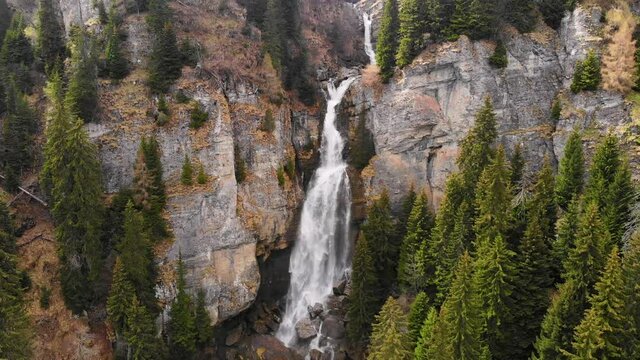 Drone flying over a green forest around a big waterfall in the mountains. Aerial Drone footage 4K. Beautiful nature landscape scene showing the famous waterfall in the Carpathian Mountains, Vanturis