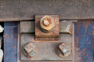 Close-up of old and rusty railroad screws and a nut