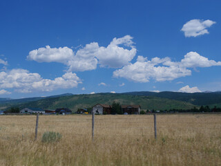 Beautiful clouds hovering above farmlands and farmhouses in Wyoming, USA.