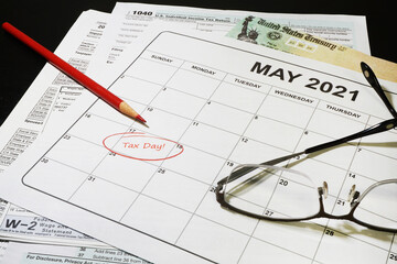 Tax documents and calender with May 17th circled and the words Taxes Due circled in red.