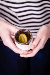 Female hands holding cup of lemon tea, copy space