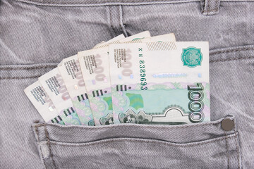 Paper 1000 banknotes of russian rubles in a jeans pocket, savings and economy concept