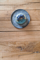 Fototapeta na wymiar Blue american pancakes decorated with blueberry and caramel souse on vintage plate on wood table. Homemade tasty food. Celebration of Shrovetide. Top view. Copy space.