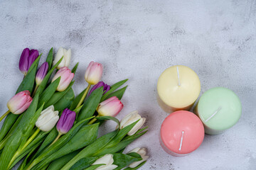 Candles and a bouquet of tulips from above on a gray background. Happy holiday concept ER