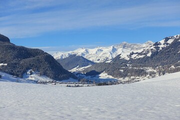 Fototapeta na wymiar Scenic View Of Snowcapped Mountains Against Blue Sky Gstaad Luxury Swiss Alps Alpine Resort