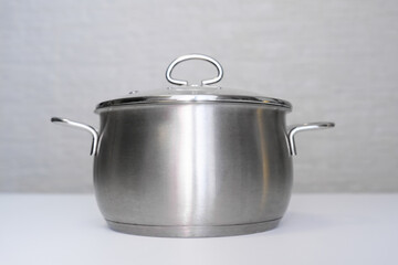 Stainless steel pot, stockpot on white table, eco friendly kitchen utensils without harm, harmless safe for people