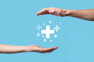 Male hand holding plus icon on blue background. Plus sign virtual means to offer positive thing (like benefits, personal development, social network)Profit,health insurance, growth concepts
